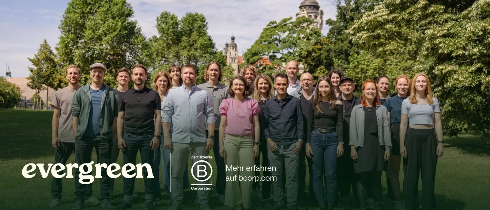 Das Evergreen-Team im Park vor dem Neuen Rathaus in Leipzig, darunter das Evergreen-Logo und das Logo Zertifizierte B Corporation mit dem Hinweis: Mehr erfahren auf bcorp.com