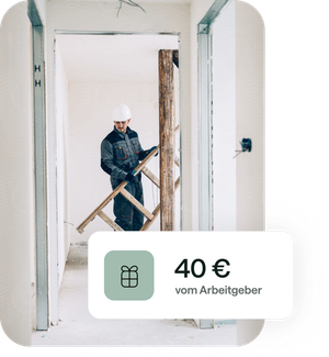 Ein Handwerker im Blaumann trägt eine Leiter aus einer Wohnung, die saniert wird.