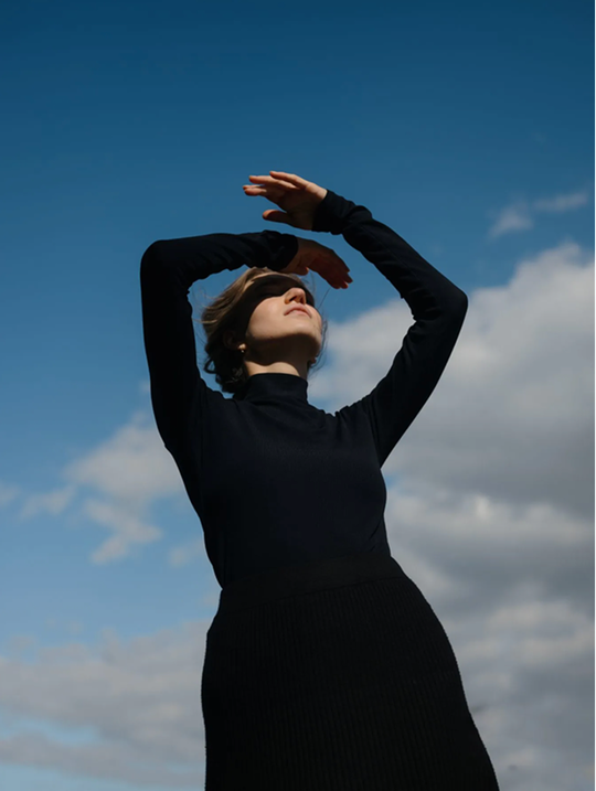 Frau blickt in den Himmel — symbolisches Bild für vorausschauende Altersvorsorge bei Evergreen.