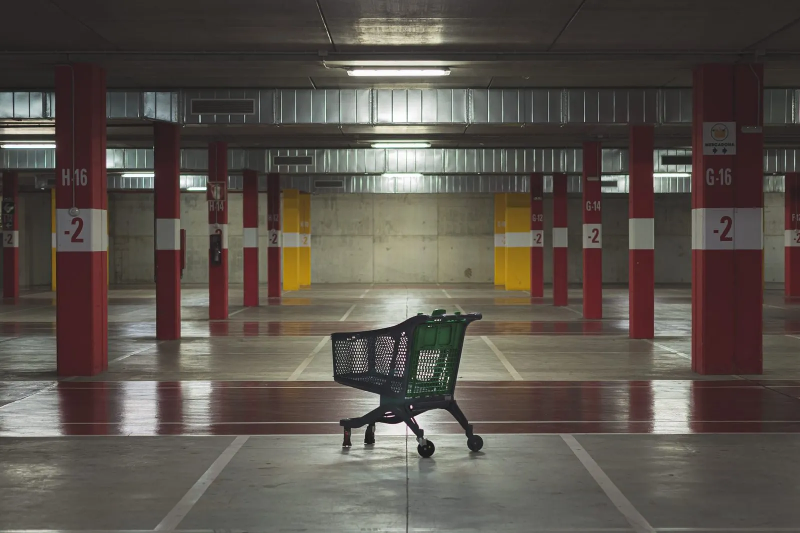Einzelner Einkaufswagen in einer leeren Tiefgarage
