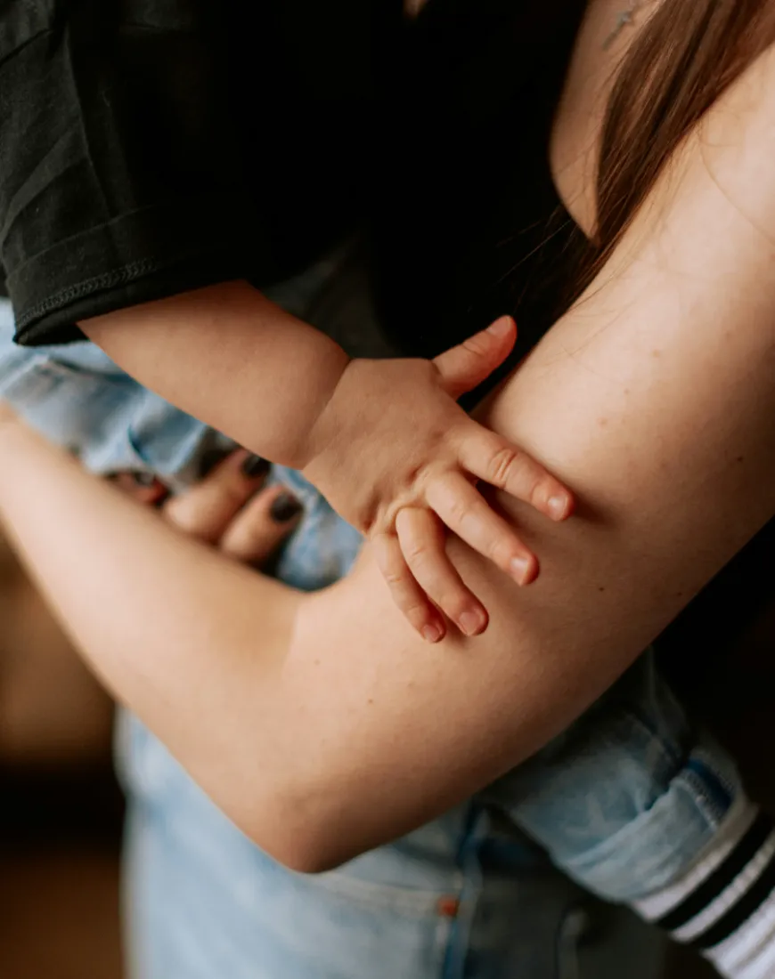 Kinderhand hält den Arm der Mutter